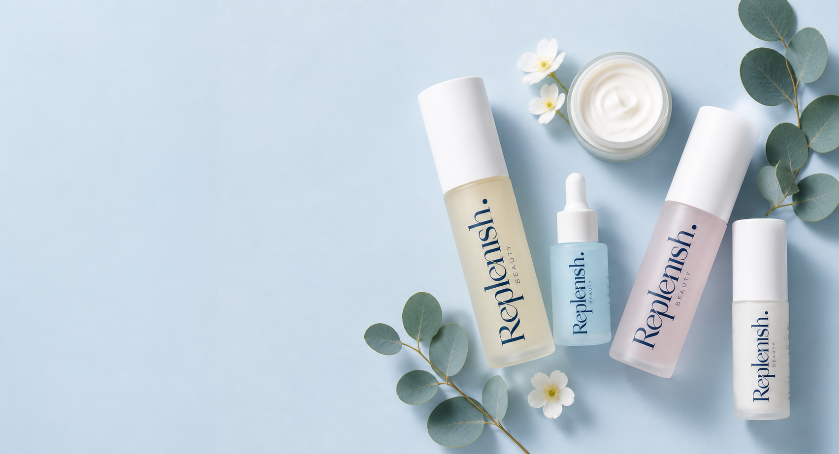 Replenish Beauty skincare laid with eucalyptus leaves in a blue studio