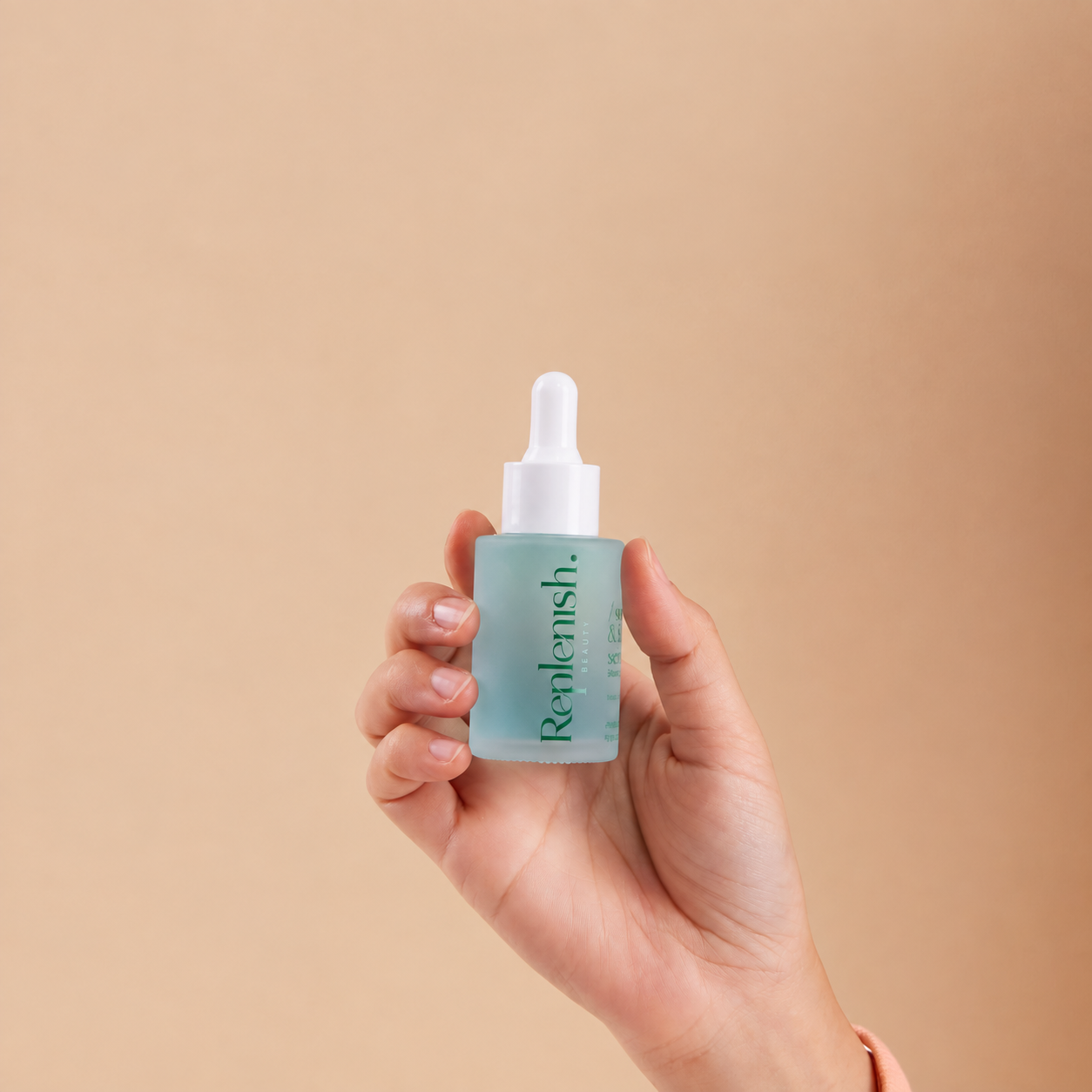 A hand holding Replenish Soothing and Balancing Serum against a light peach background